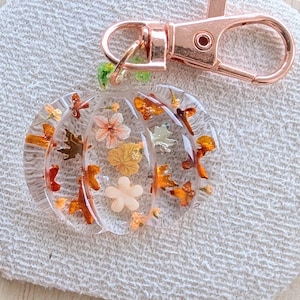 Autumn bag charm, pumpkin bag charm, rose gold coloured clip, pressed flowers pumpkin charm, pumpkin zip charm, fall bag charm, pumpkin with pressed flowers, real flowers bag charm, resin bag charm, pumpkin keyring, pressed flower pumpkin keyring, zip charm, Halloween bag charm, Halloween accessories, autumn accessories, pressed flower pumpkin charm