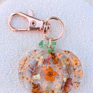 Autumn bag charm, pumpkin bag charm, rose gold coloured clip, pressed flowers pumpkin charm, pumpkin zip charm, fall bag charm, pumpkin with pressed flowers, real flowers bag charm, resin bag charm, pumpkin keyring, pressed flower pumpkin keyring, zip charm, Halloween bag charm, Halloween accessories, autumn accessories, pressed flower pumpkin charm