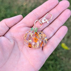 Autumn bag charm, pumpkin bag charm, rose gold coloured clip, pressed flowers pumpkin charm, pumpkin zip charm, fall bag charm, pumpkin with pressed flowers, real flowers bag charm, resin bag charm, pumpkin keyring, pressed flower pumpkin keyring, zip charm, Halloween bag charm, Halloween accessories, autumn accessories, pressed flower pumpkin charm