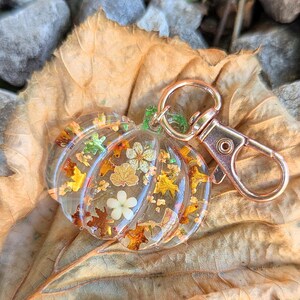 Autumn bag charm, pumpkin bag charm, rose gold coloured clip, pressed flowers pumpkin charm, pumpkin zip charm, fall bag charm, pumpkin with pressed flowers, real flowers bag charm, resin bag charm, pumpkin keyring, pressed flower pumpkin keyring, zip charm, Halloween bag charm, Halloween accessories, autumn accessories, pressed flower pumpkin charm