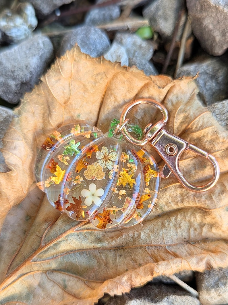 Autumn bag charm, pumpkin bag charm, rose gold coloured clip, pressed flowers pumpkin charm, pumpkin zip charm, fall bag charm, pumpkin with pressed flowers, real flowers bag charm, resin bag charm, pumpkin keyring, pressed flower pumpkin keyring, zip charm, Halloween bag charm, Halloween accessories, autumn accessories, pressed flower pumpkin charm