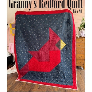 May include: Granny's Redbird Quilt, measuring 68 x 80 inches, features a large red cardinal design on a navy blue background with small floral patterns. The quilt has a red border and the text "Granny's Redbird Quilt" at the top.