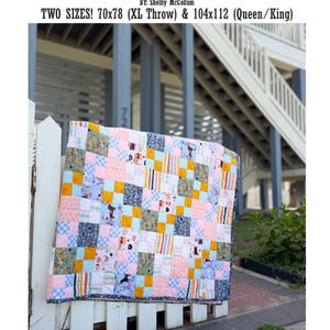 May include: A patchwork quilt featuring a grid of multi-colored fabric squares in shades of pink, yellow, blue, and green with various floral and patterned prints. The text reads THE BIG PATCHWORK QUILT BY: Shelby McCollum TWO SIZES! 70x78 & 104x112.