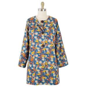 May include: A long-sleeved floral print coat with a button closure. The coat is blue with a floral pattern in shades of orange, yellow, and white.