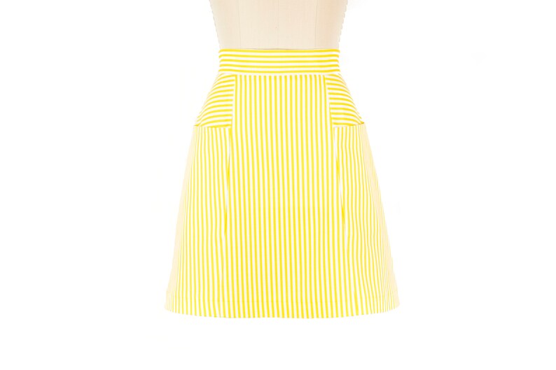 May include: A yellow and white striped skirt with two pockets on the front.
