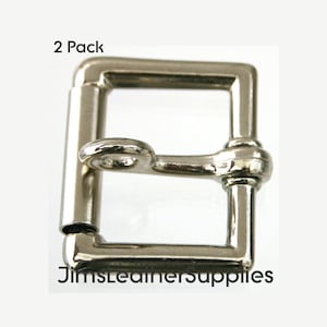 May include: Two silver-toned metal buckles, each with a square frame and a rounded, spring-loaded tongue. The buckles are designed for use with straps or belts.