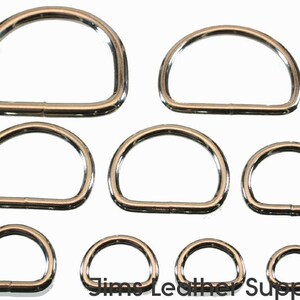 May include: Set of eight silver-toned metal D-rings in various sizes. The rings are smooth and have a polished finish.