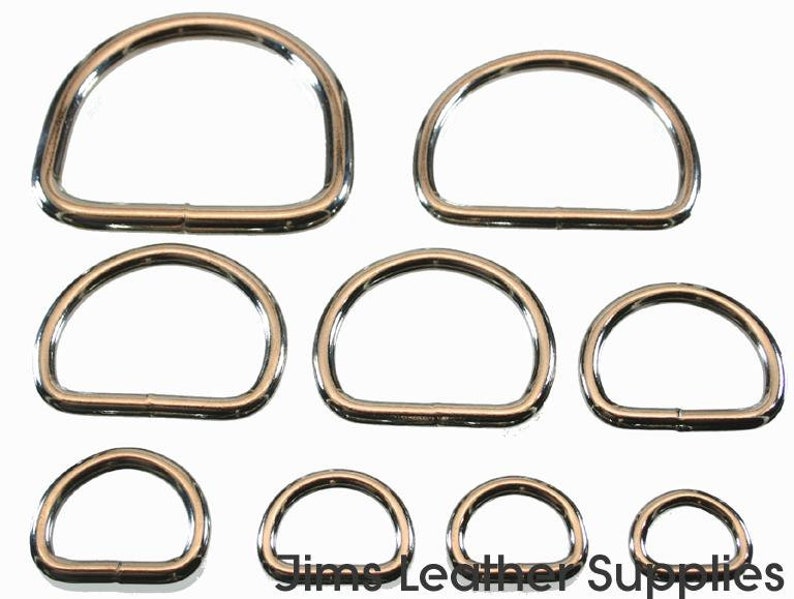 May include: Set of eight silver-toned metal D-rings in various sizes. The rings are smooth and have a polished finish.