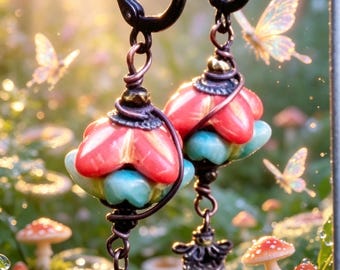 May include: A pair of whimsical earrings with red and turquoise floral designs, suspended from black hoops. The earrings have intricate metalwork and dangle with decorative charms. The background features butterflies and mushrooms, suggesting a fairy tale theme.