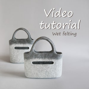 May include: Two grey and white felt bags with handles. The bags have a gradient colour pattern and a rectangular cutout on the front. The text "Video tutorial Wet felting" is displayed above the bags.