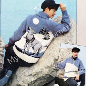 May include: A blue and white knitted sweater with a wolf design. The sweater has a zipper and a high collar. The model is wearing a black hat.
