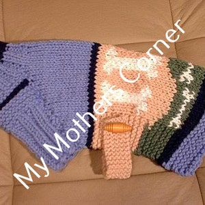 Könnte beinhalten: Ein gestrickter Hundepullover mit einem mehrfarbigen Streifenmuster. Der Pullover hat ein hellblaues, rosa, grünes und weißes Streifenmuster. Der Pullover hat ein knochenförmiges Design auf der Vorderseite. Der Pullover hat einen Holzknopf auf der Vorderseite.