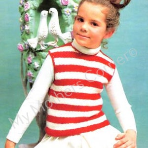 Könnte beinhalten: Ein junges Mädchen trägt eine weiße und rot gestreifte Strickweste. Die Weste hat einen Rundhalsausschnitt und ist ärmellos. Das Mädchen trägt einen weißen Rock und hat ihre Haare zu einem Dutt gesteckt.