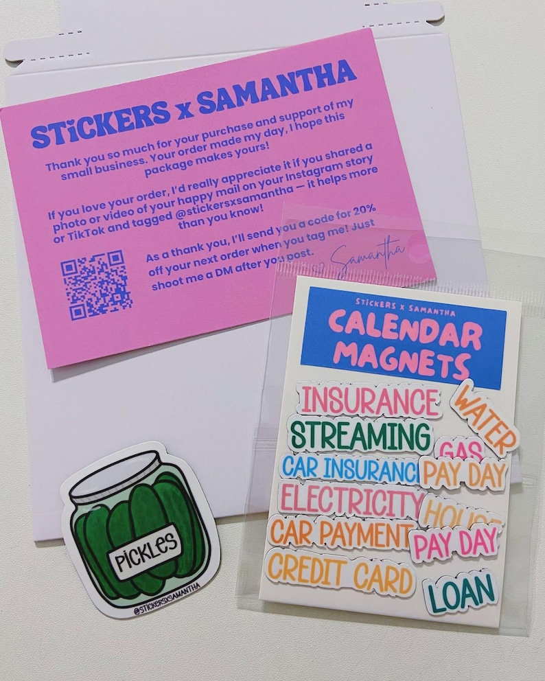 May include: A pink thank you card with blue text, a clear plastic bag containing calendar magnets with various labels like Insurance, Streaming, and Pay Day, and a separate sticker of a jar of green pickles with the text Pickles.