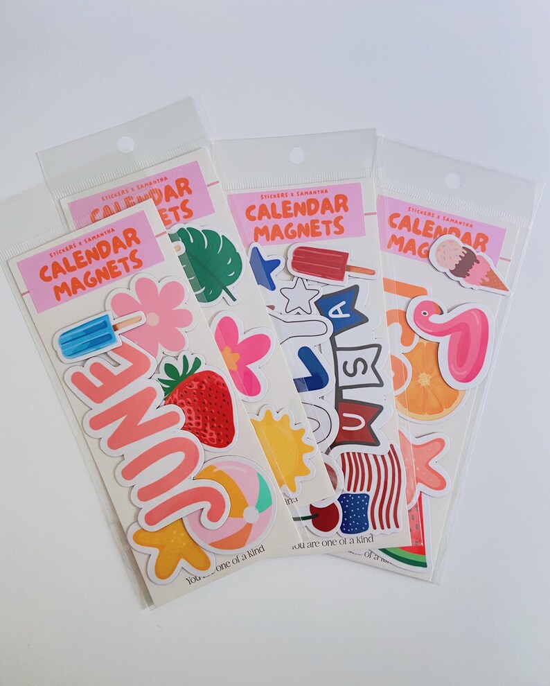 May include: Three clear plastic packages of calendar magnets labeled CALENDAR MAGNETS. The stickers feature colorful summer-themed designs including a strawberry, a beach ball, a popsicle, a flamingo, an orange slice, and the text JUNE.