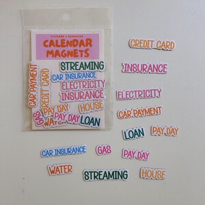 May include: A set of colorful calendar magnets in a clear plastic sleeve, featuring various text labels including Credit Card, Insurance, Electricity, Car Payment, Pay Day, House, Loan, Gas, Water, and Streaming, printed in diverse fonts and colors.