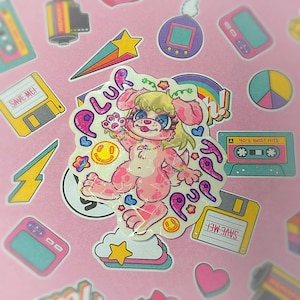 Puede incluir: Una colección de pegatinas coloridas sobre un fondo rosa. La pegatina central presenta un perro de dibujos animados con pelaje rosa y la palabra "PLUR". Otras pegatinas incluyen una cinta de cassette, un arcoíris y una carita sonriente.