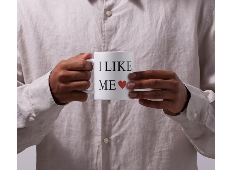 May include: White ceramic mug with black text that reads "I LIKE ME" and a red heart.