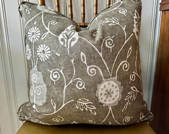 May include: A brown and white floral patterned throw pillow with a subtle distressed look. The pillow is sitting on a gold chair.