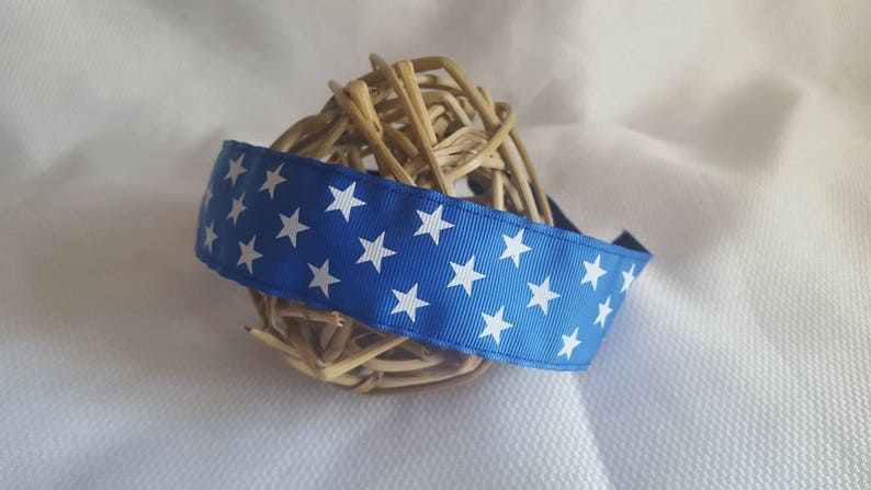 May include: A blue headband with white stars printed on it. The headband is wrapped around a woven ball of twigs.