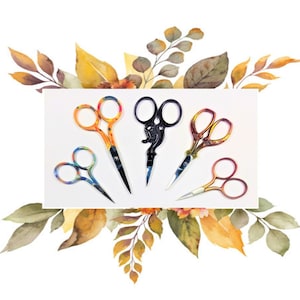 May include: Five pairs of decorative scissors with colorful handles and silver blades. The scissors are arranged in a row on a white background with a watercolor floral design.