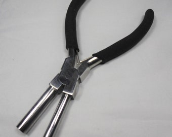 May include: Black handled pliers with two long, silver, metal jaws. The pliers are designed for closing jump rings.