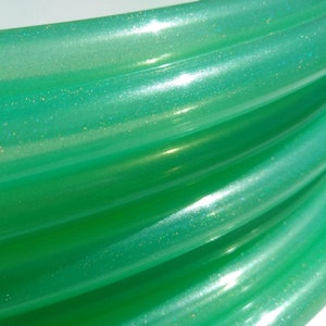 May include: Close-up of a green iridescent hoop with glitter embedded in the plastic.