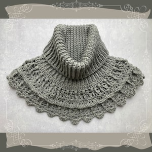 Puede incluir: Un cuello de lana gris tejido a crochet con un cuello ancho y doblado y un borde festoneado.