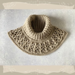 May include: A beige crocheted cowl with a wide, lacy bottom and a close-fitting neck.