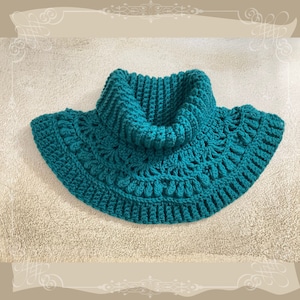 May include: Teal crocheted cowl with a wide, scalloped edge and a high, folded collar.
