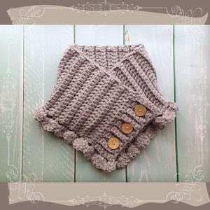 May include: A gray crocheted cowl with a scalloped edge and three wooden buttons.