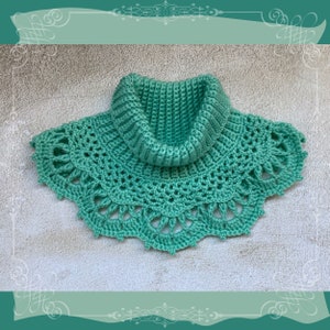 May include: A teal crocheted cowl with a wide, lacy bottom and a high, ribbed collar.