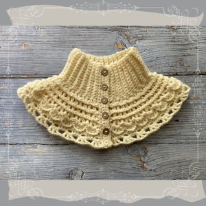 May include: A crocheted yellow collar with a scalloped edge and five brown buttons.