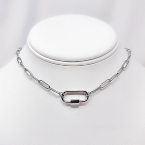 May include: A silver chain necklace with a silver oval-shaped clasp.