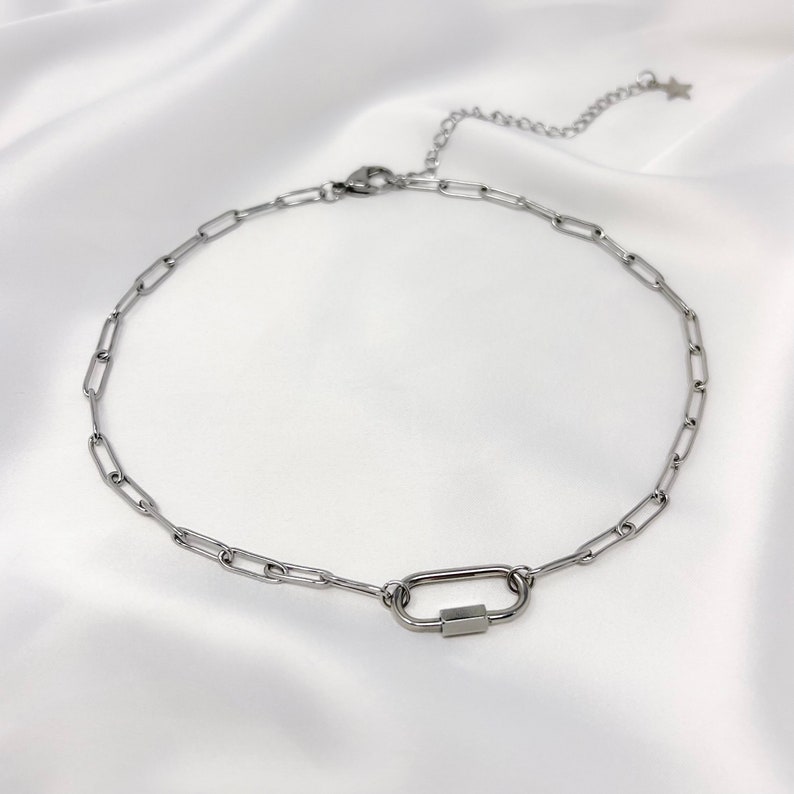 May include: A silver chain necklace with a silver carabiner clasp.