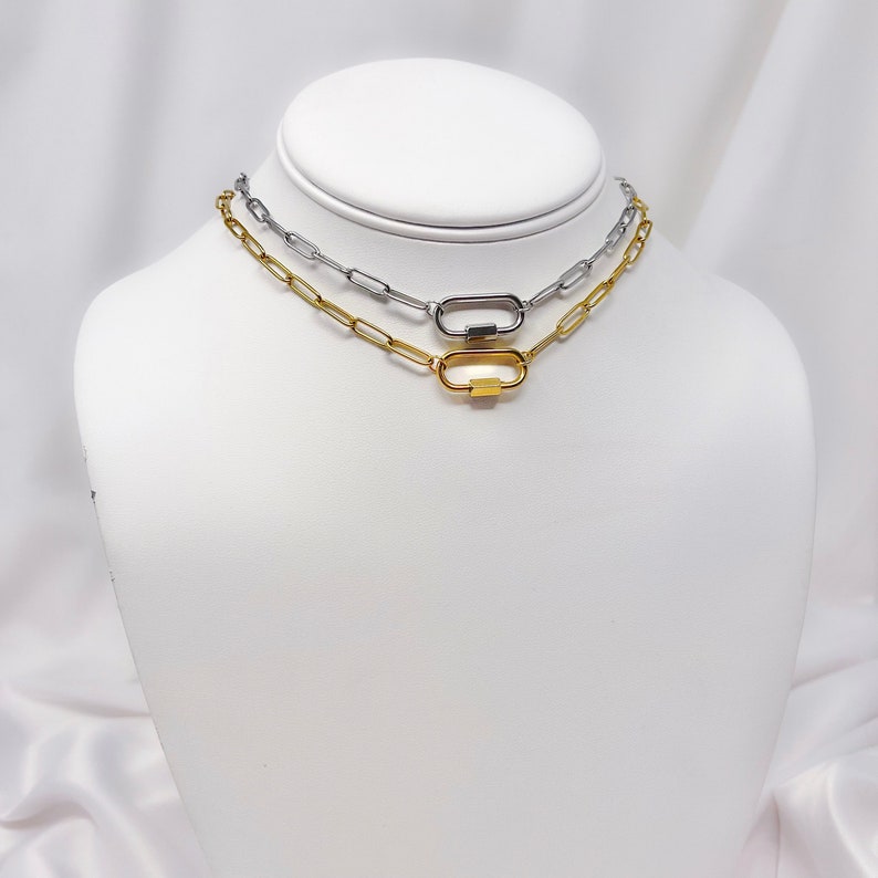 May include: Two gold and silver chain necklaces with a clasp closure. The necklaces are layered on a white mannequin.