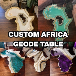 May include: Four custom-made coffee tables shaped like the continent of Africa. Each table features a different color resin with gold accents and a geode design. The tables are on a wooden floor.