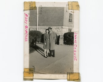 Könnte beinhalten: Schwarzweißfoto eines Paares, das vor einem Backsteingebäude steht. Die Frau trägt einen Mantel und der Mann einen Anzug. Das Foto ist mit "Mary G. Hiker" und "James Cornez" beschriftet.
