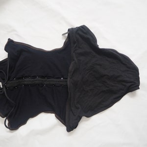Puede incluir: Un body negro con cordones, escote redondo y espalda baja. El body est&aacute; hecho de una tela suave y el&aacute;stica y tiene un ajuste c&oacute;modo.