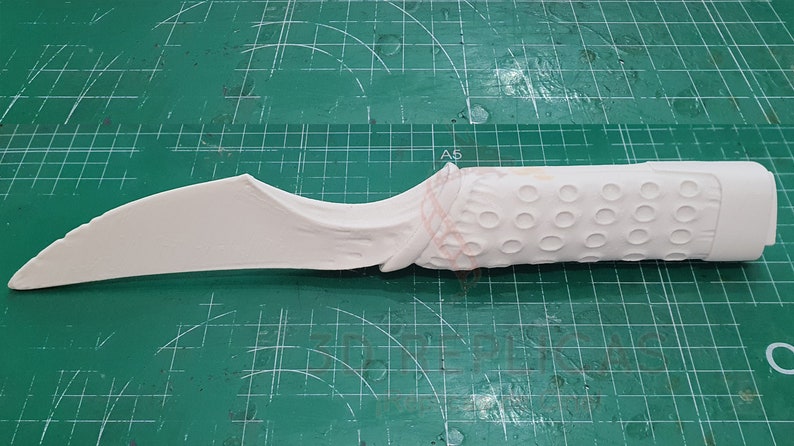 May include: A white plastic knife with a textured handle. The handle has a pattern of small circles.
