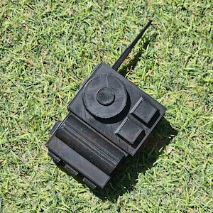 May include: A black plastic toy radio with a long antenna. The radio has a circular button and a rectangular button on the front.