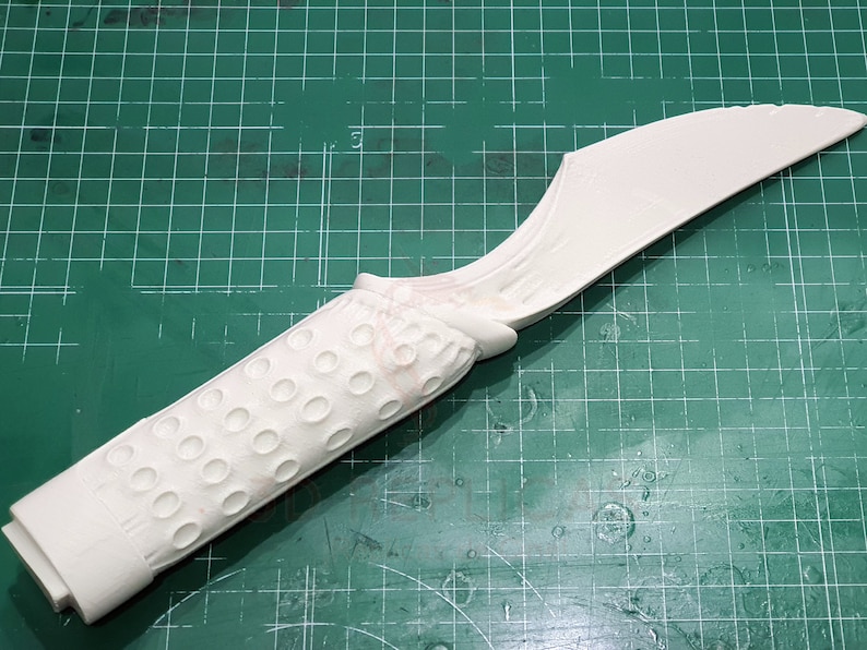May include: White plastic prop knife with a textured handle and a curved blade.