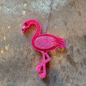 May include: Pink glitter flamingo ornament with a white string for hanging.