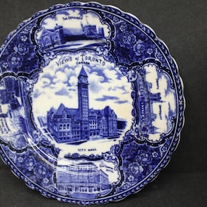 Może przedstawiać: Niebiesko-biały talerz dekoracyjny z ilustracjami zabytków Toronto. Talerz ma falisty brzeg i kwiatową obwódkę. Tekst na talerzu brzmi "Views of Toronto Canada" i "City Hall".