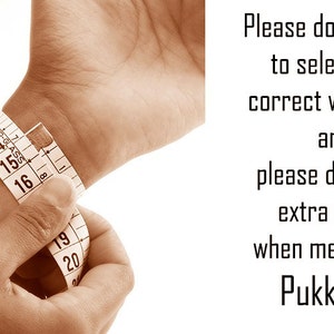 May include: A person's wrist is measured with a white measuring tape. The tape is wrapped around the wrist, showing measurements in inches. Text on the right side of the image reads: "Please don't forget to select your correct wrist size and please don't add extra space when measuring. PukkaMen."