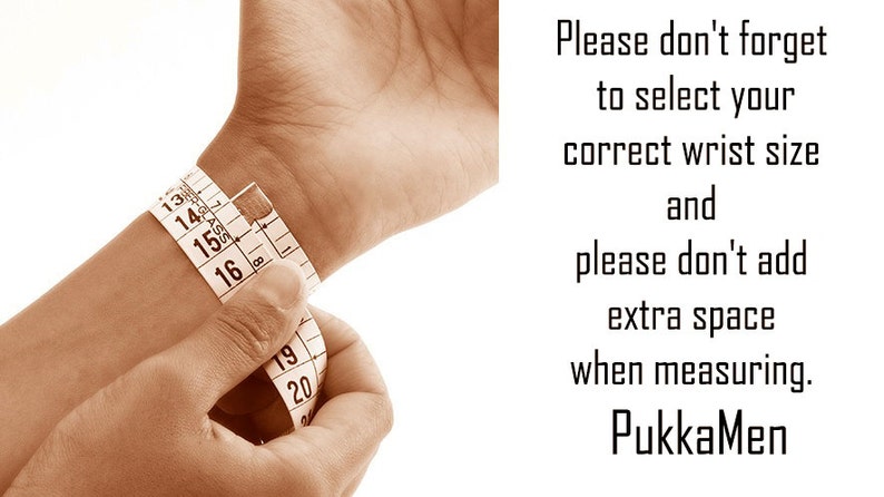 May include: A person's wrist is measured with a white measuring tape. The tape is wrapped around the wrist, showing measurements in inches. Text on the right side of the image reads: "Please don't forget to select your correct wrist size and please don't add extra space when measuring. PukkaMen."