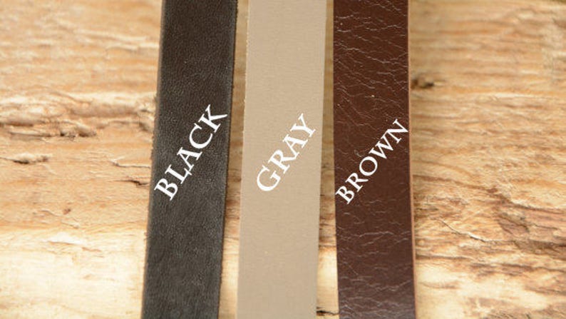 May include: Three leather straps in black, gray, and brown with the color name printed in white on each strap.