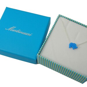 May include: A blue opal elephant pendant necklace in a blue and green striped gift box. The box is labeled "Martinauzzi".