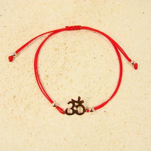 Om Bracelet. Sterling silver Om Yoga symbol and sturdy red cord with gold filled ball ends.