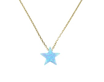 May include: A delicate gold chain necklace with a blue opal star pendant.